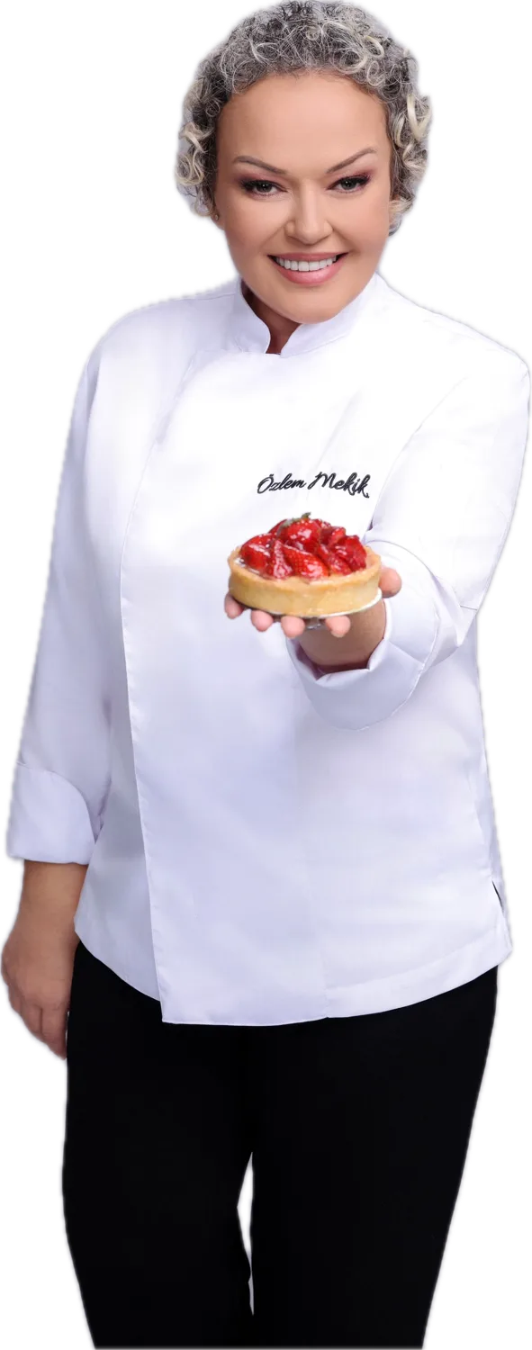 Özlem Mekik, şef ceketiyle elinde çilekli tart